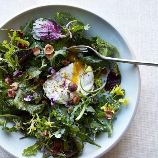 Mixed greens with poached eggs, hazelnuts and spices