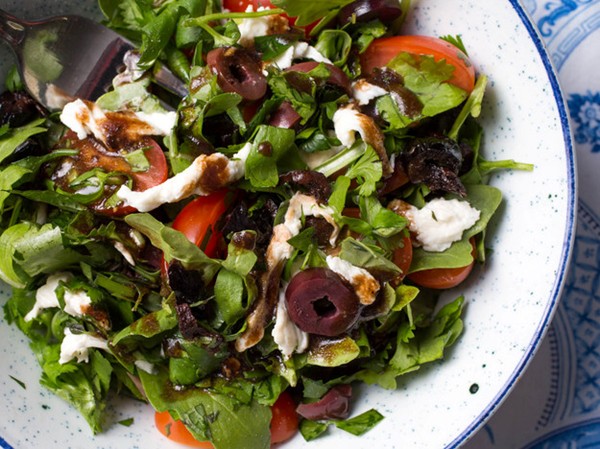Mixed herbs salad with olives, tomatoes, and fresh mozzarella