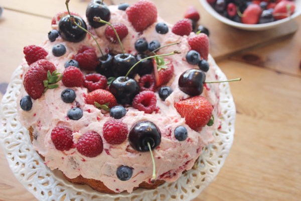 Mixed summer berry bundt cake with strawberries and cream icing