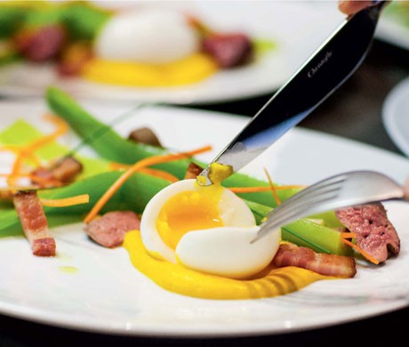 Modern salade Lyonnaise, leeks, lardons, and oeuf mollet