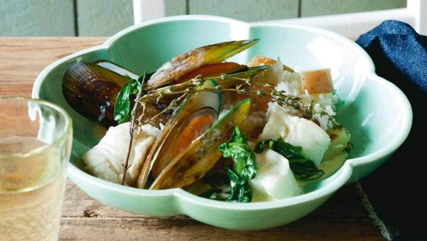 Mussels and fish with spinach and cream on red potatoes and rice