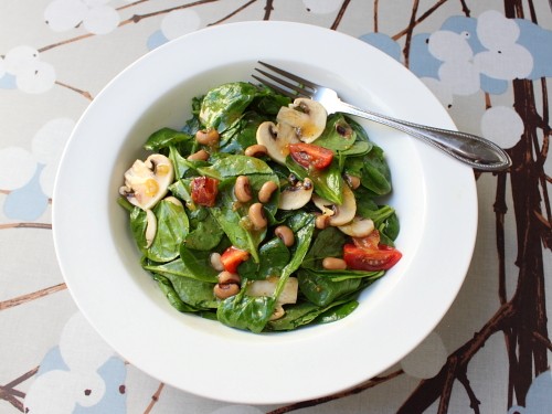New Year's day spinach salad with hot bacon dressing
