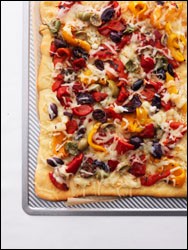 Niçoise pizza with olives, red peppers, and Gruyère