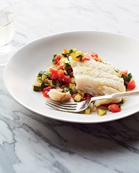 Olive oil-poached hake on sautéed zucchini with tomatoes