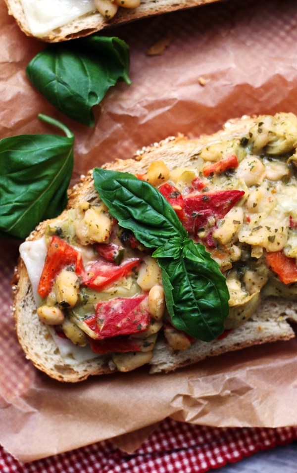 Open-faced white bean, artichoke, and pesto salad sandwich melts