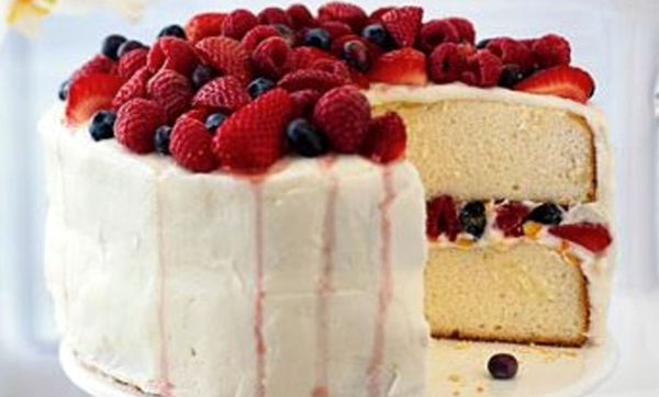 Orange layer cake with buttercream frosting and berries