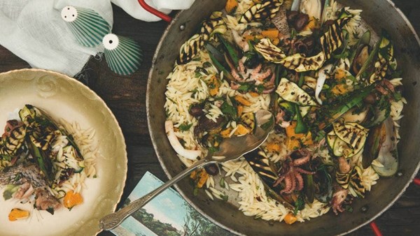 Orzo pasta with seafood, zucchini, capers and olives