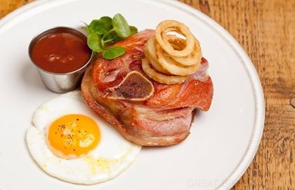 Osso buco of gammon with gooseberry ketchup, fried duck egg and crispy pickled onion rings