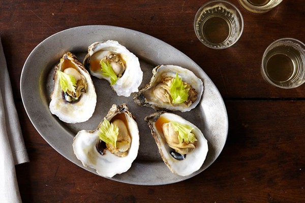 Oysters with caramelized honey, tomato broth, celery leaves and chili