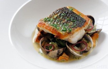 Pan-fried sea bass, butter spinach, clams, poached cod cheeks and fish sauce