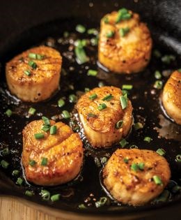 Pan-seared diver scallops over kale