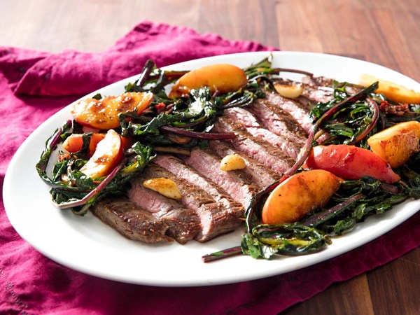 Pan-seared flank steak with peaches and dandelion greens