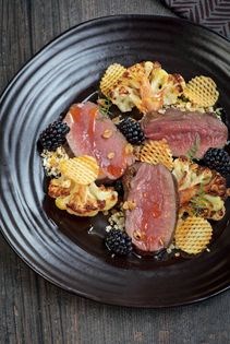 Pan-seared loin of venison with raw-spiced cauliflower, brambles & game chips