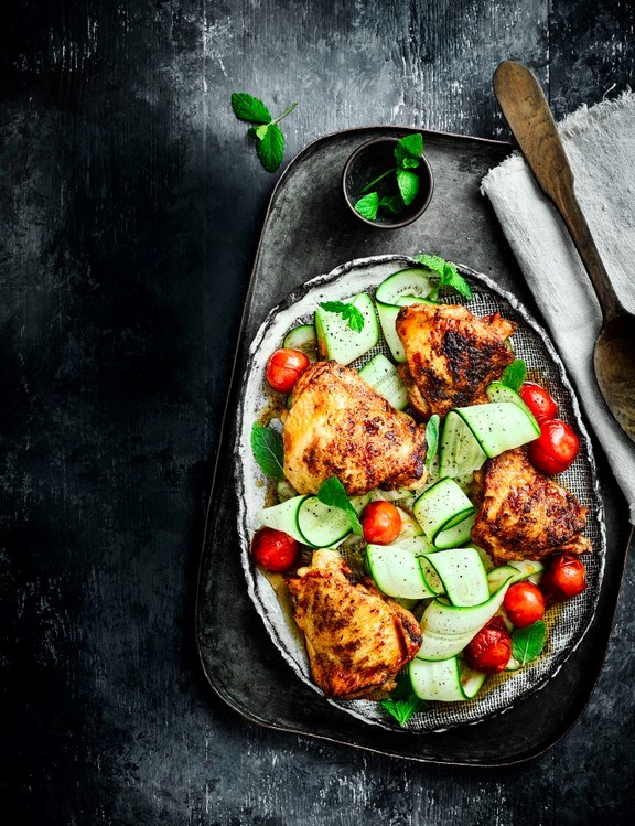 Paprika chicken thighs with cherry tomatoes, courgette ribbons and mint