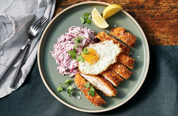 Parmesan-crumbed chicken schnitzel, fried eggs and apple and cabbage slaw