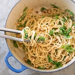 Pasta with roasted garlic sauce, arugula, and walnuts