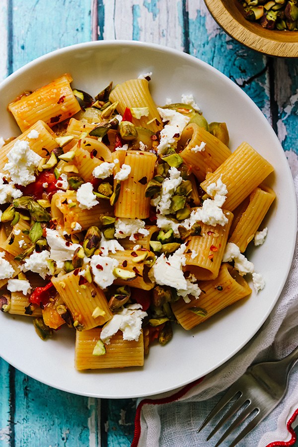 Pasta with zucchini, tomatoes, pistachios, and feta