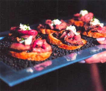 Pepper-crusted steak with horseradish cream on grilled garlic crostini