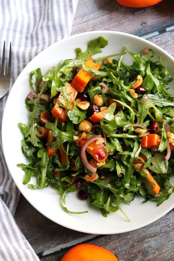 Persimmon and pomegranate salad with arugula and hazelnuts