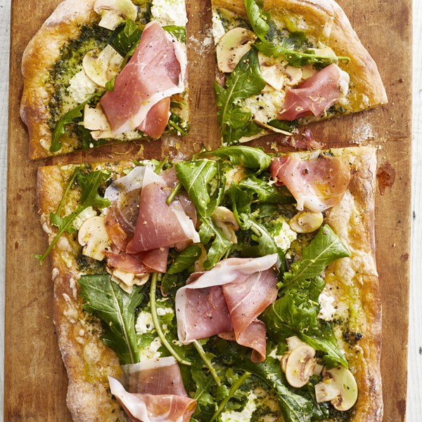 Pesto pizza with arugula and prosciutto