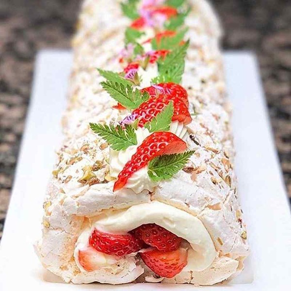 Pistachio meringue roulade with strawberries and elderflower cream