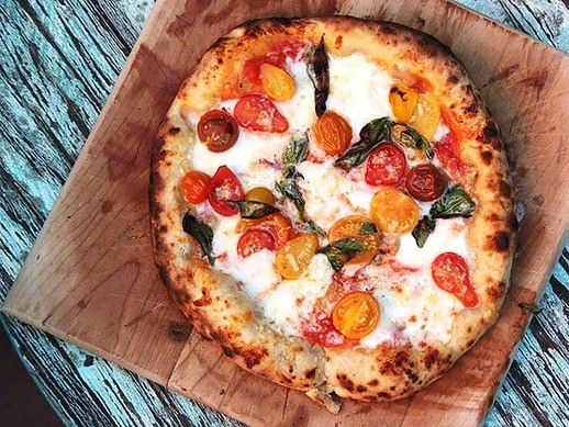 Pizza with cherry tomatoes, garlic, basil, and mozzarella