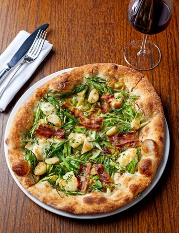 Pizza with goat's cheese, leeks, spring onions, garlic and pancetta