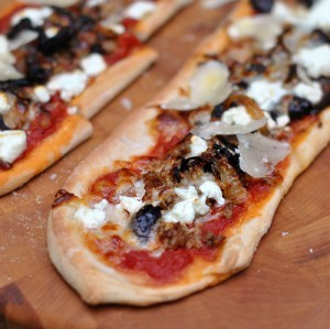 Pizza with ground goat, goat cheese, onion, and black olives