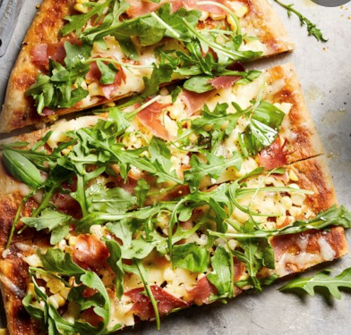 Pizza with prosciutto, corn & arugula