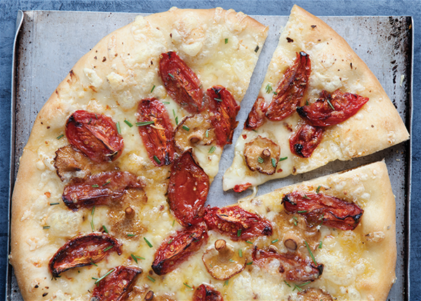 Pizza with smoked hedgehog mushrooms, slow-roasted tomatoes, and Fontina