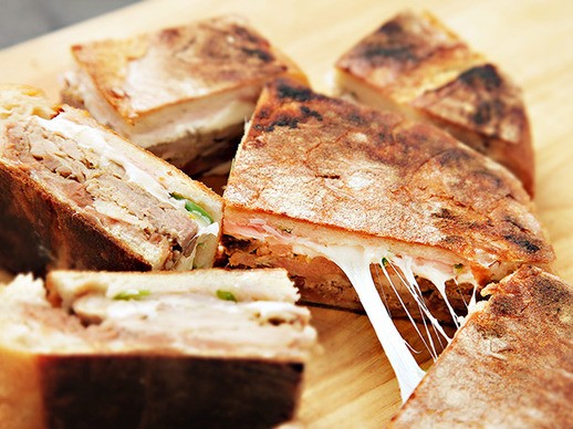 Pork carnitas and Oaxaca cheese shooter's-sandwich with spicy refried beans and pickled red onions