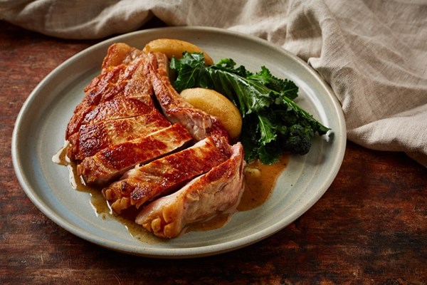 Pork chop in a cider cream sauce with caramelised apples and purple sprouting broccoli