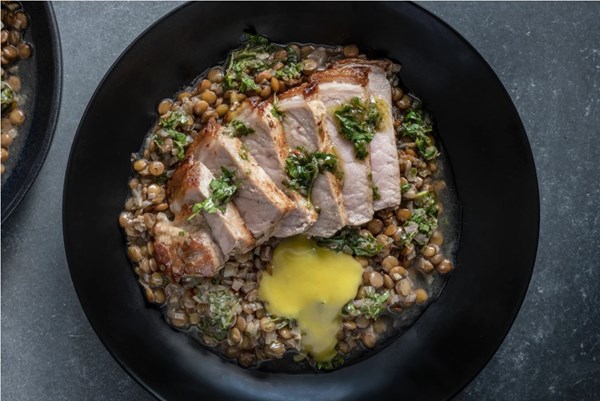 Pork chop with braised lentils, chimichurri and saffron aioli