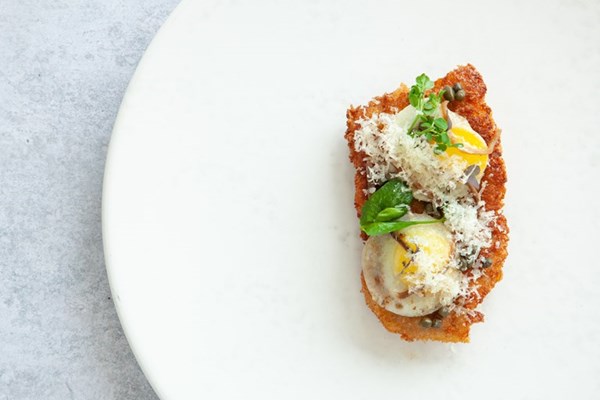 Pork schnitzel with Le Gruyère AOP Réserve, quail eggs, capers and anchovies