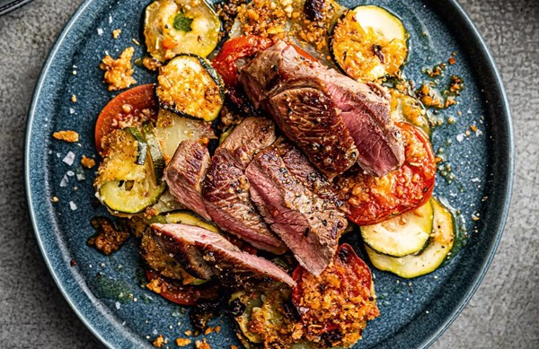 Potato, courgette & tomato gratin with grilled lamb steaks