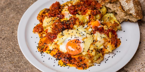 Potatoes with spiced sugo, curds and fried eggs