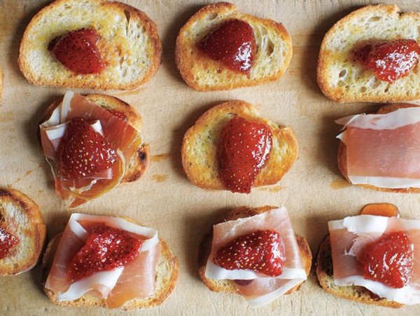 Preserved strawberries and jamón serrano on little toasts