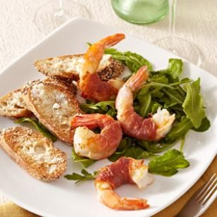 Prosciutto-wrapped shrimp with arugula salad
