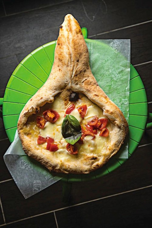Racket-shaped pizza with mushrooms and tomatoes (Rachetta)