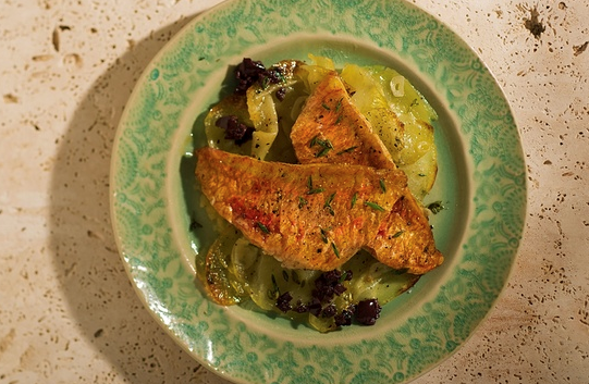 Red mullet with sliced potatoes and black olives