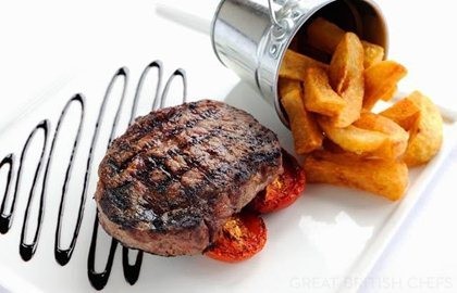 Rib-eye steak with chunky chips, field mushrooms and vine tomatoes
