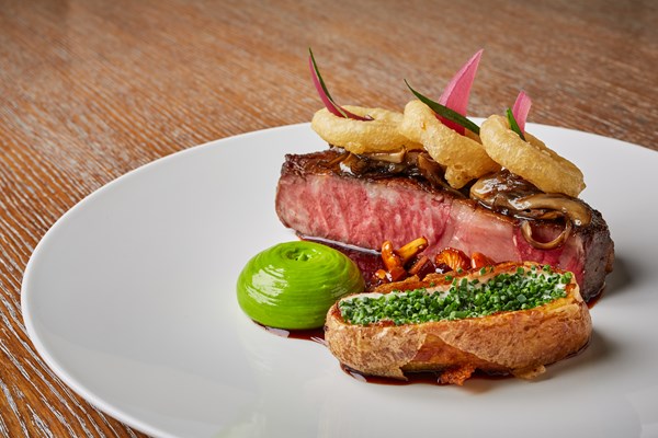 Rib-eye with sour cream and chive potato, chive mayonnaise and onion rings
