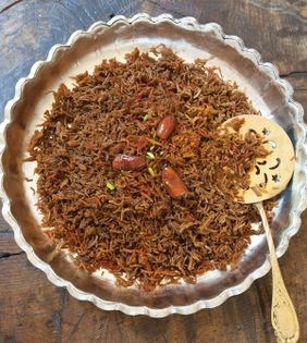 Rice steamed in date molasses (Shireh-ye khorma polow)