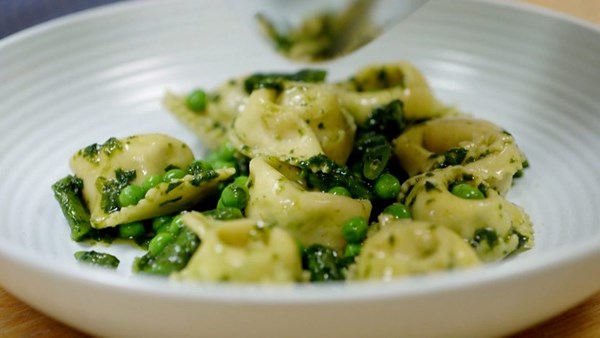 Ricotta and herb cappellacci with pesto, peas and beans