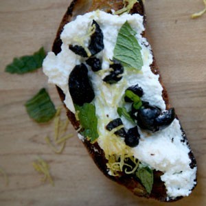 Ricotta crostini with black olives, lemon zest, and mint