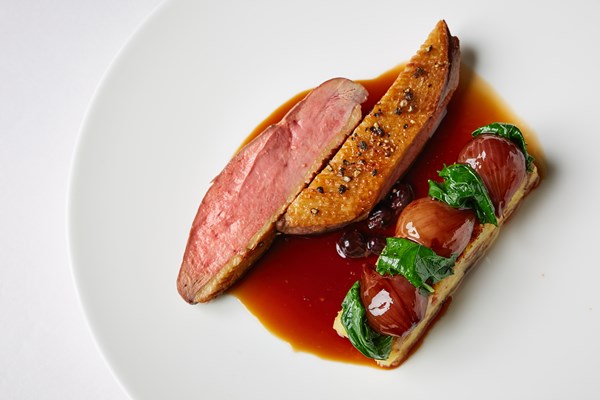 Roast Challans duck with confit leg sarladaise, cime de rapa and blackcurrant sauce
