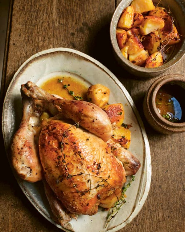 Roast chicken with roast potatoes and roasting juices