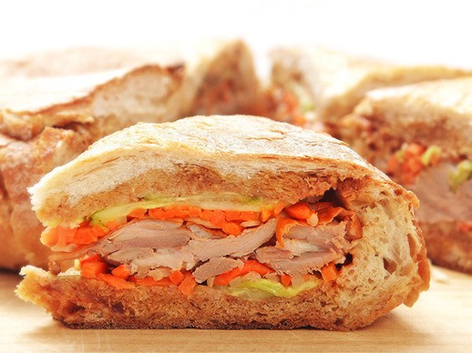 Roast duck shooter's-style sandwich with pickled carrots, daikon, cucumber, and hoisin sauce