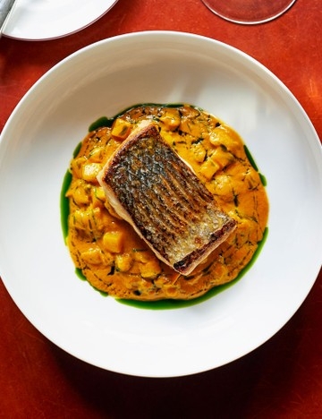 Roast fillet of seabass with braised shellfish and saffron sauce