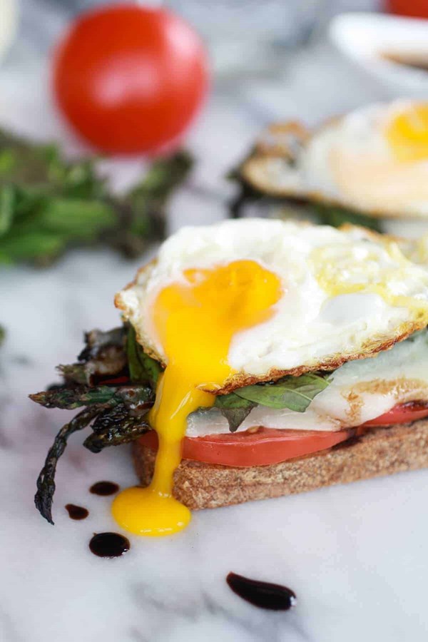Roasted asparagus Caprese melts with balsamic reduction and fried egg